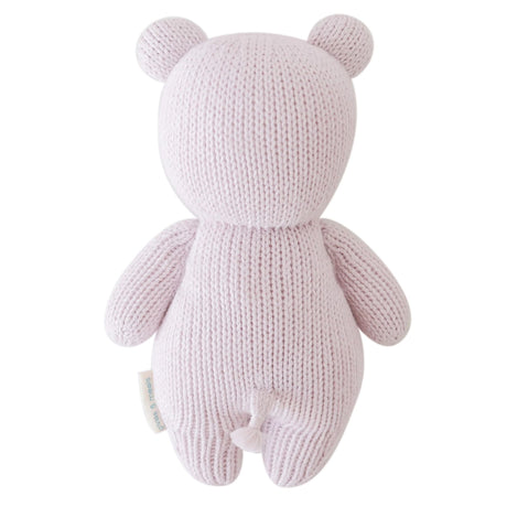 Knitted pink teddy bear toy on a white background