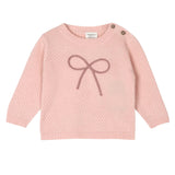 Pink knitted sweater with a bow design on a white background