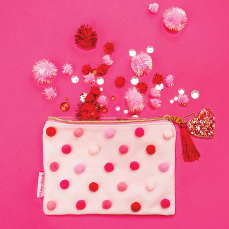 Pink pouch with pom-pom details on a pink background