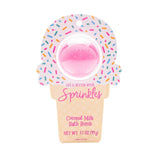 Pink bath bomb in a donut-shaped container with sprinkles on a white background