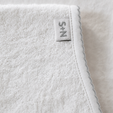 Close-up of a textured fabric with a brand label on a light background
