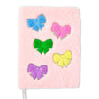 Pink notebook with colorful glittery bows on a white background