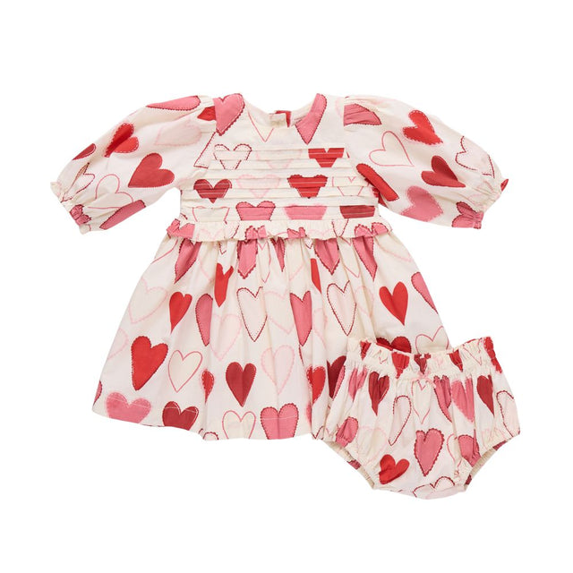 Baby dress and bloomers with heart pattern on a white background