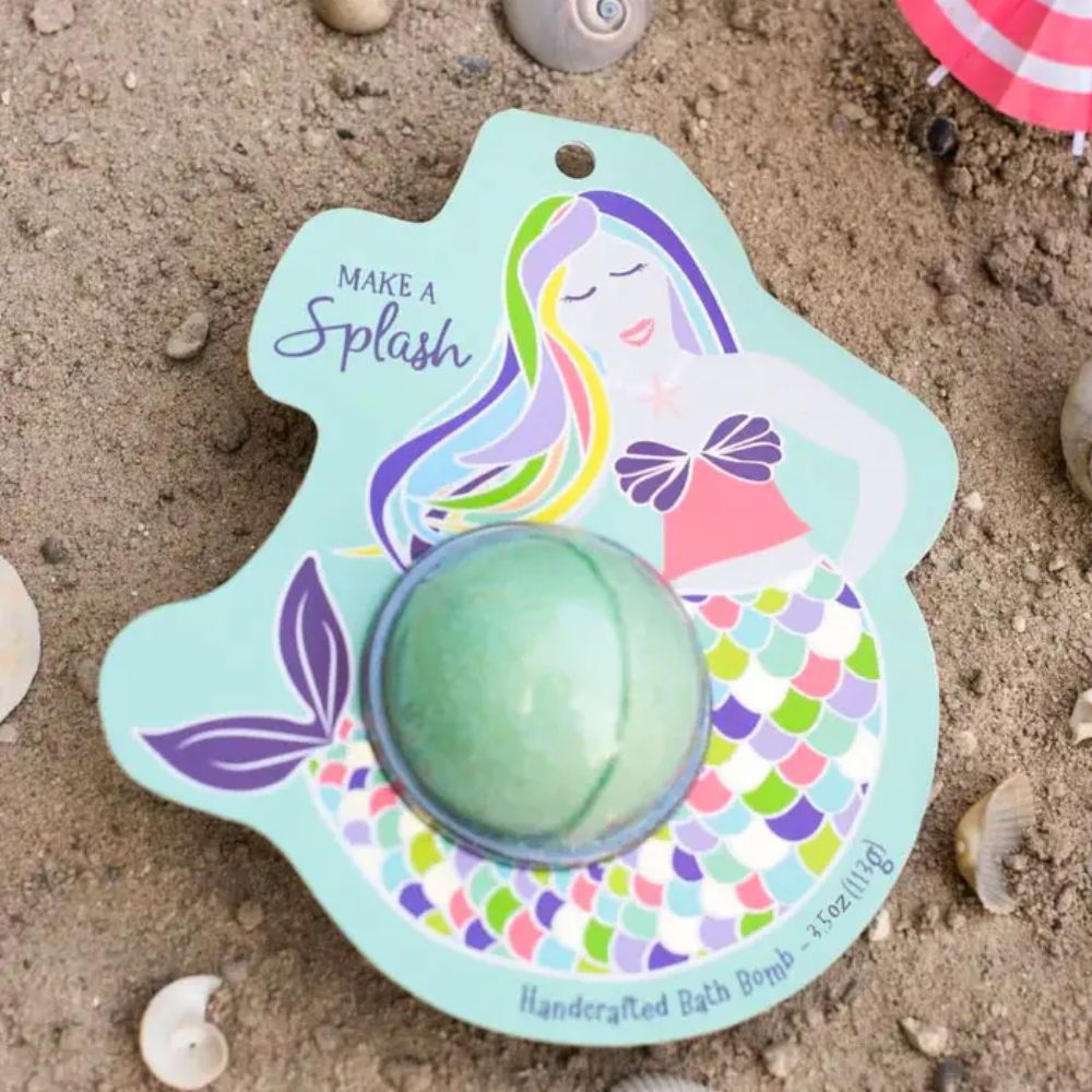 Mermaid-themed bath bomb on a sand background