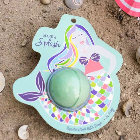 Mermaid-themed bath bomb on a sand background