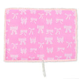Pink blanket with white bow pattern on a white background