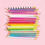 Colorful pencils arranged in a pattern on a pink background