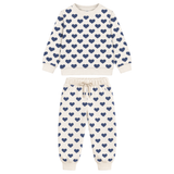 A two-piece children's sweatshirt and jogger pants set in cream with a repeating navy blue heart pattern, displayed on a solid white background.