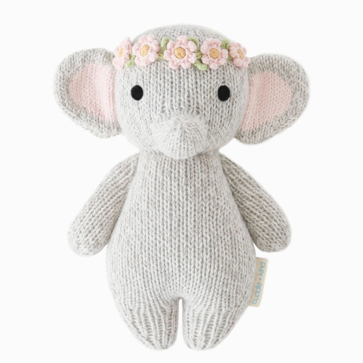Knitted elephant toy with a floral headband on a white background