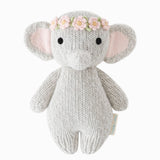 Knitted elephant toy with a floral headband on a white background