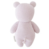Knitted pink teddy bear toy on a white background