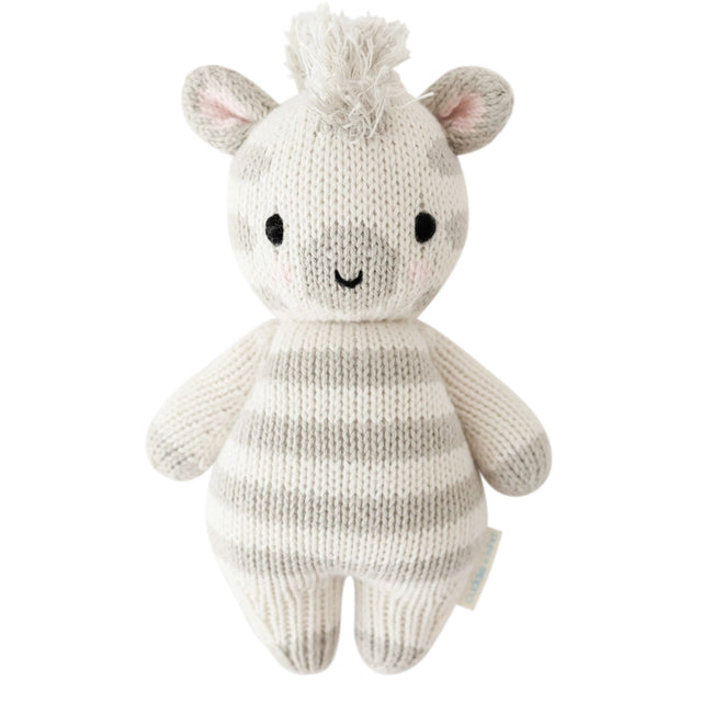 Knitted toy zebra with a white and gray striped body on a white background