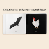 Open book with illustrations of a bat and a hen on black pages.