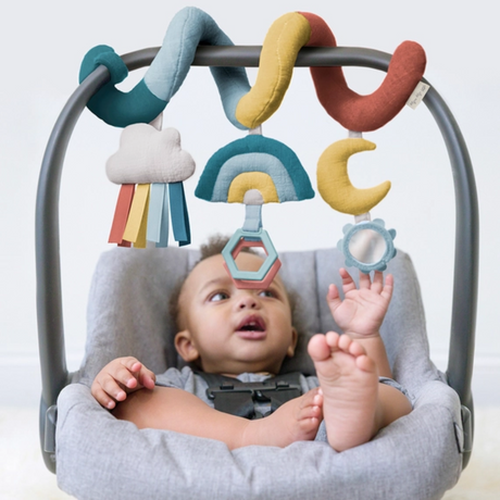 a baby palying with Rainbow Bespoke Spiral Car Seat Activity Toy