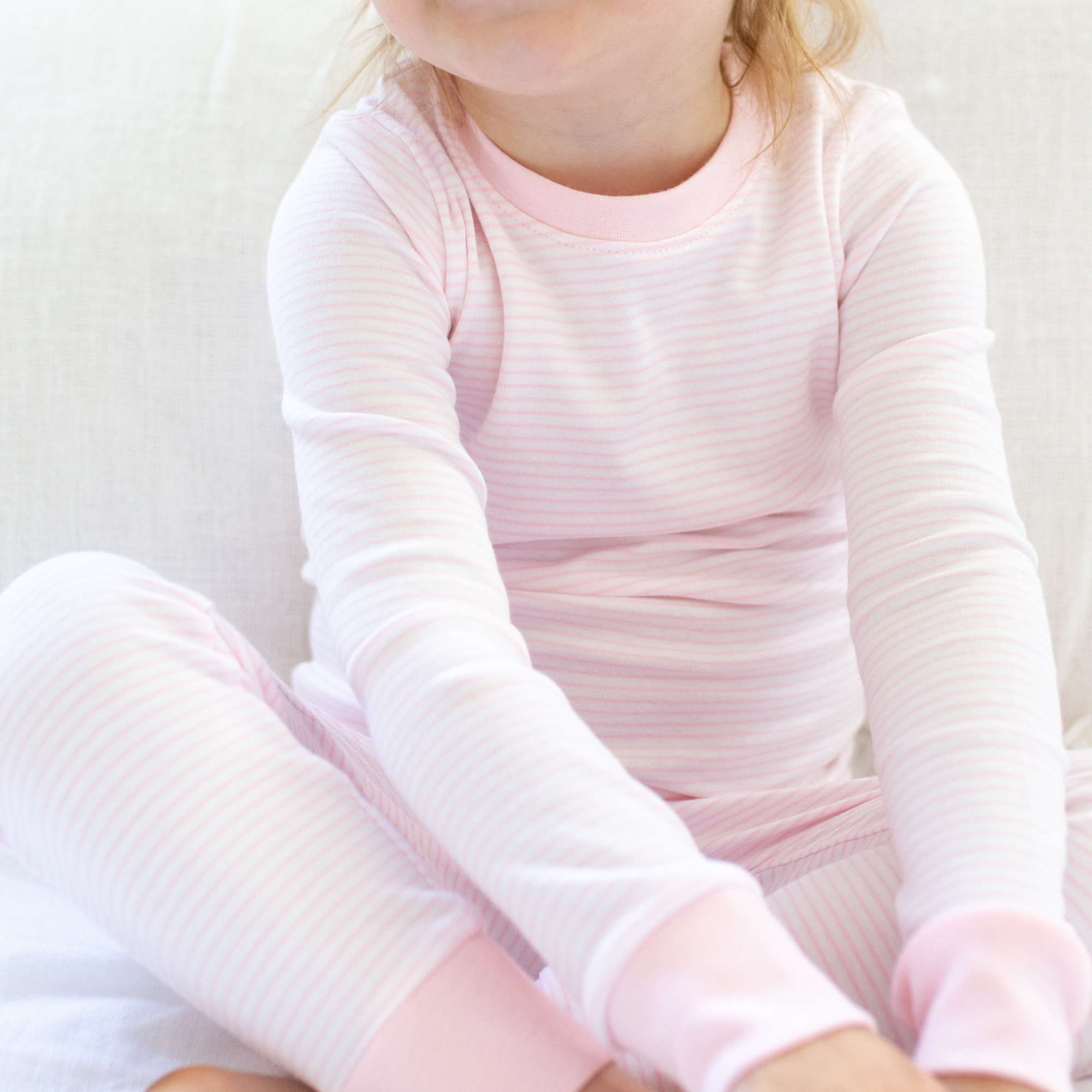 a little girl wearing Classic Stripe Pajama Set in Pink