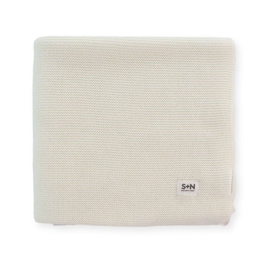 Beige knitted blanket with a brand logo on a white background