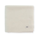 Beige knitted blanket with a brand logo on a white background