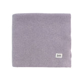 Purple knitted blanket with a brand label on a white background