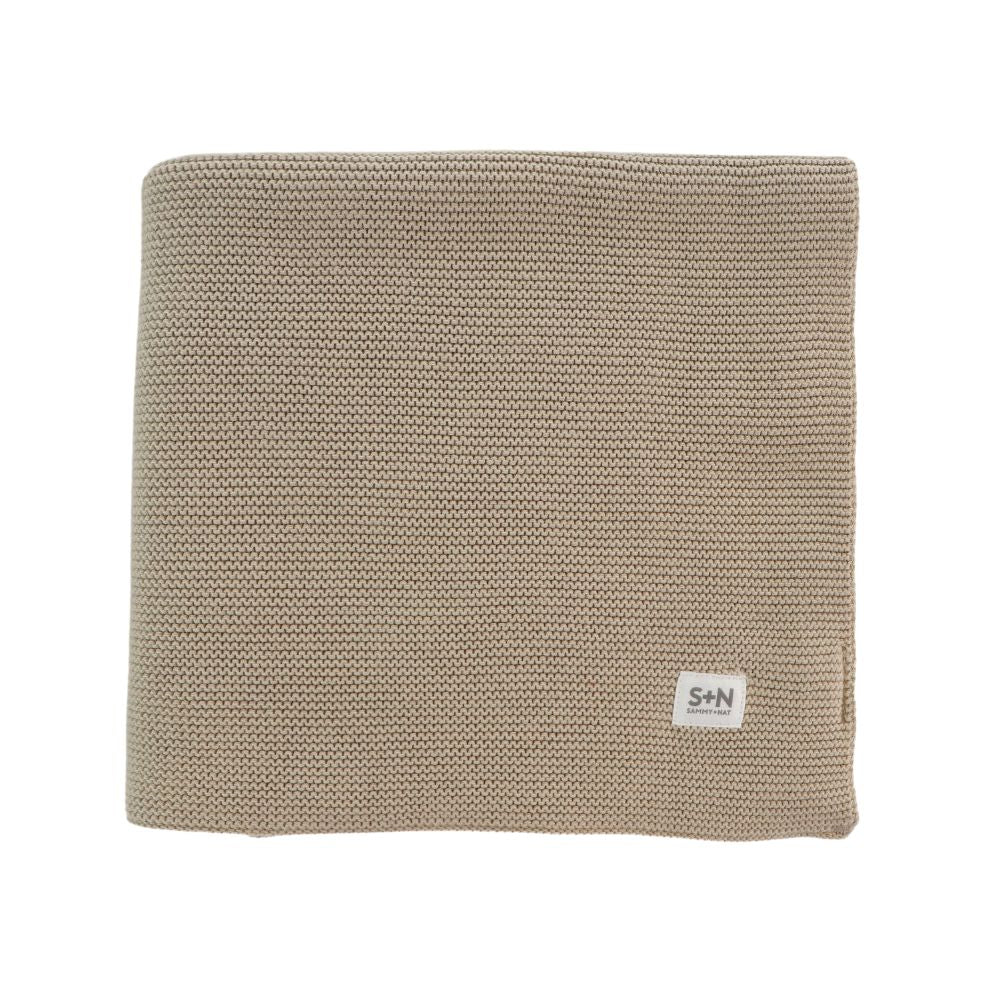 Beige knitted blanket with a brand label on a white background