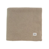 Beige knitted blanket with a brand label on a white background