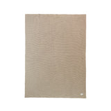 Beige blanket with a subtle pattern on a white background