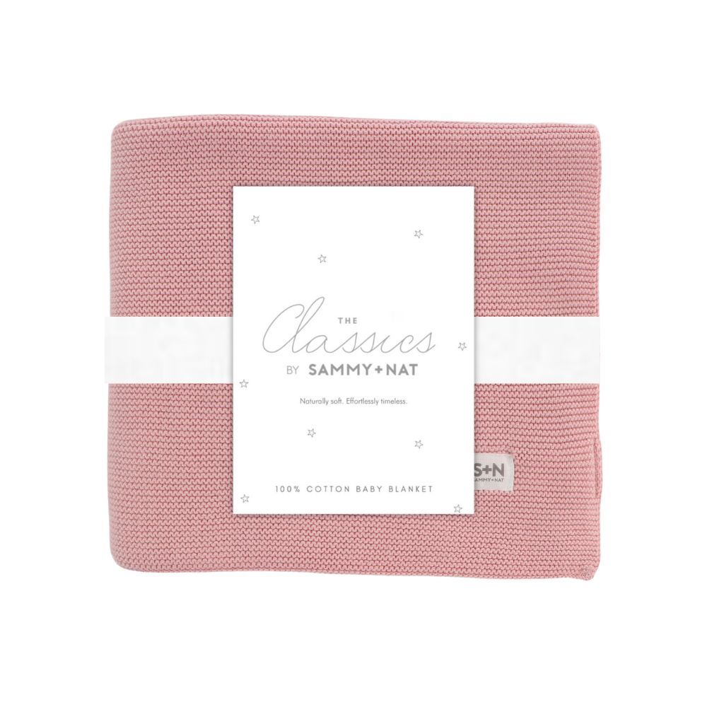 Pink baby blanket with a white label on a white background