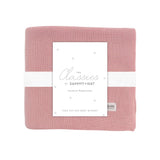 Pink baby blanket with a white label on a white background