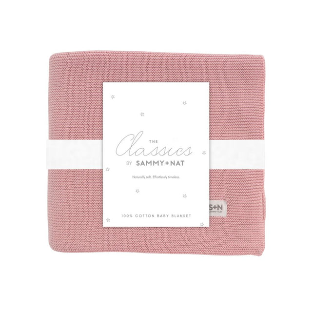 Pink baby blanket with a white label on a white background