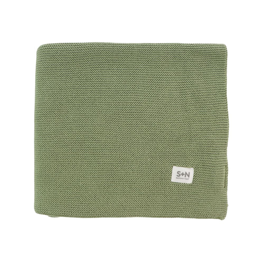 Green knitted blanket with a brand label on a white background