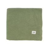 Green knitted blanket with a brand label on a white background