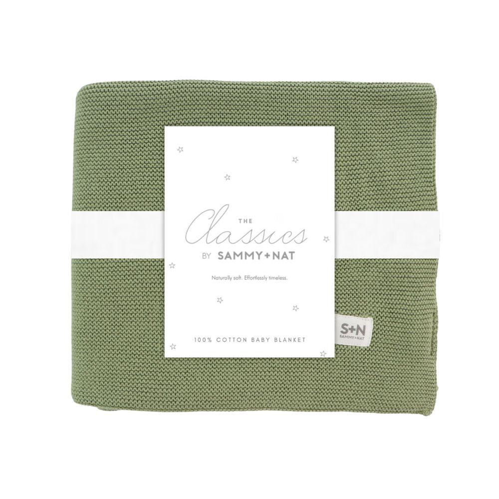 Green baby blanket with a white label on a white background