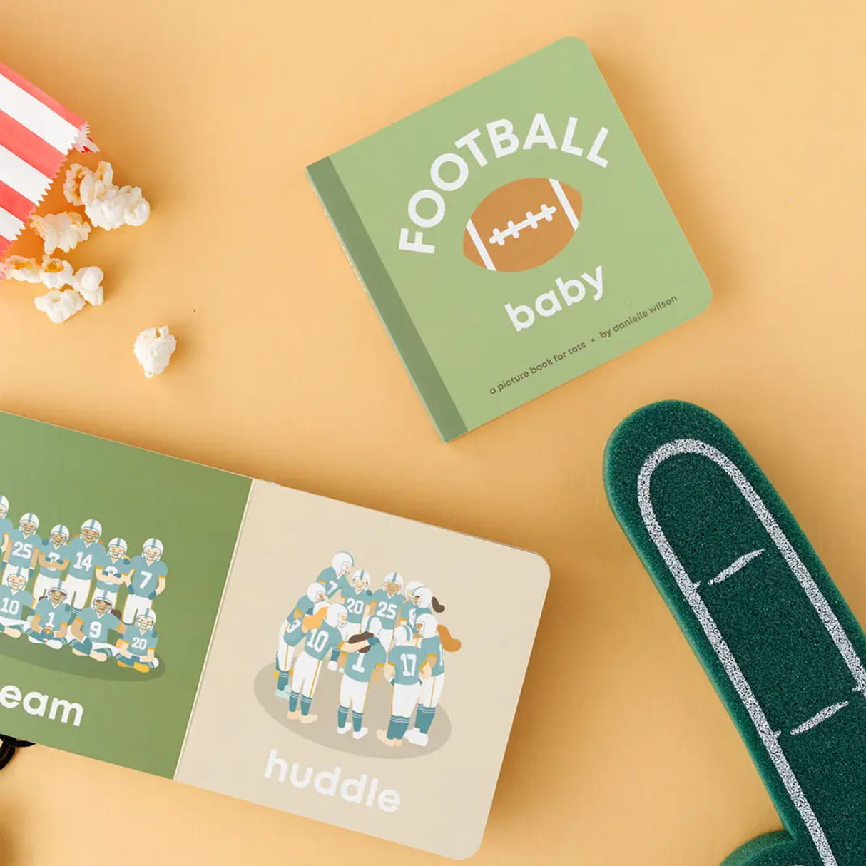 Children's books about football on a yellow background with popcorn and a toy.