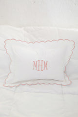 Pink scalloped pillow on white background with pink monogrammed initails