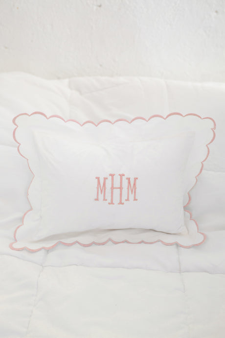 Pink scalloped pillow on white background with pink monogrammed initails