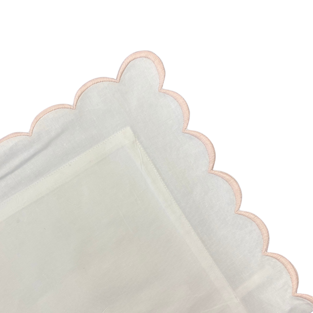 white pillow with pink trim on a white background