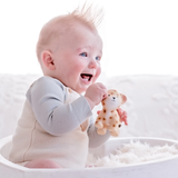 Baby holding a toy in a white crib