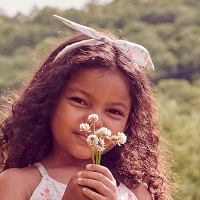 a little girl wearing Lola Hairband in Multi Muted Flowers