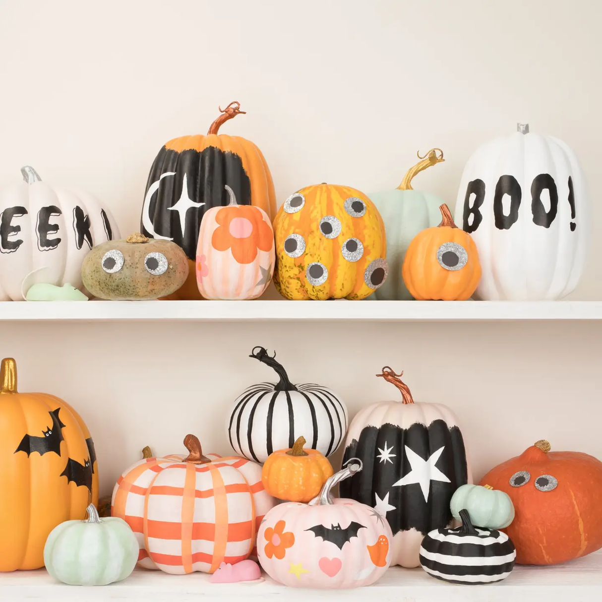 Decorative pumpkins with various designs on a white shelf