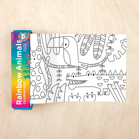 Coloring book with rainbow animal design on a wooden surface