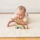 a baby playing Ritzy Rainbow Stacking Toy