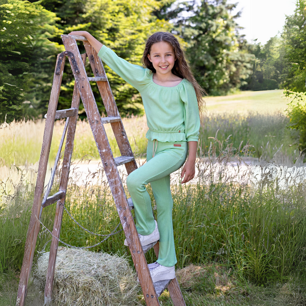 Sady Flared Pants in Spring Meadow Green a girl standing on a ladder