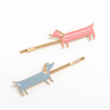 Two dog-shaped hair clips, one pink and one blue, on a white background.