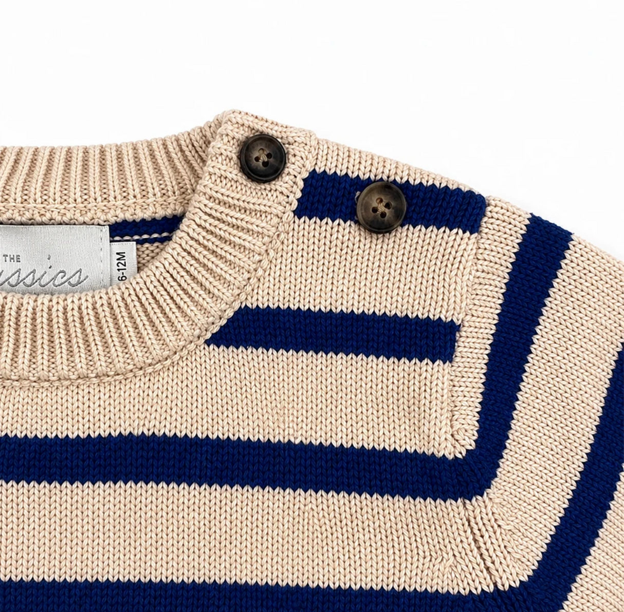 Close-up of a beige and blue striped sweater with button details on a white background.