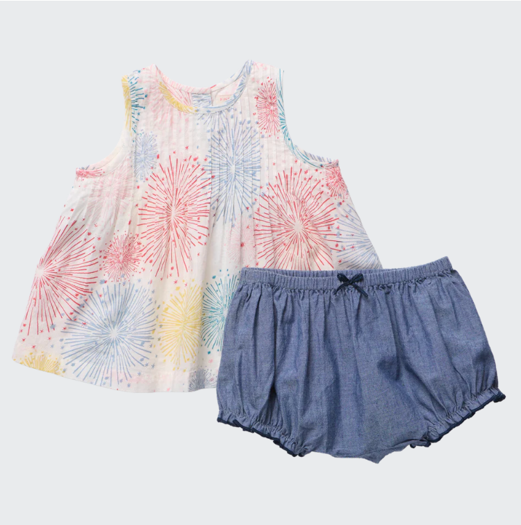 Colorful sleeveless top with firework pattern and denim shorts on a light gray background