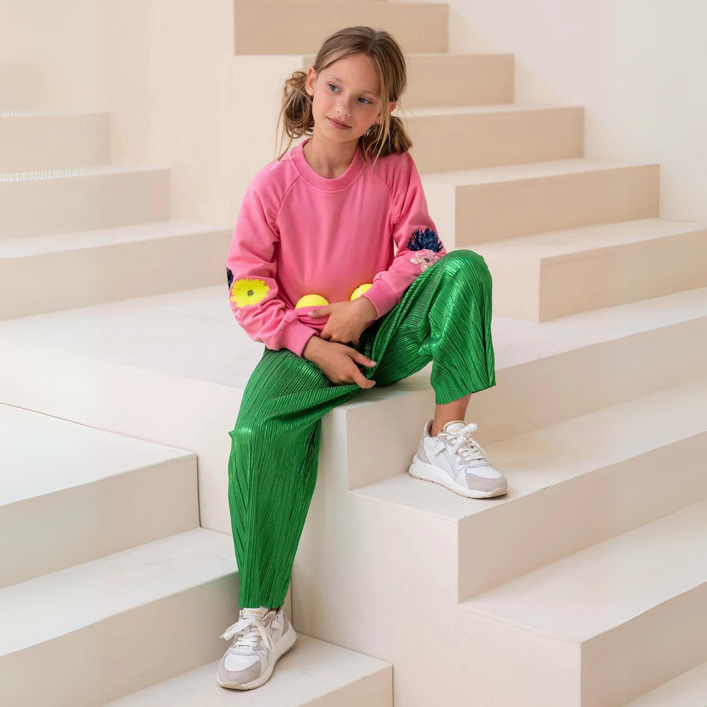 Paris Trouser in Metallic Green a girl sitting on a stairs