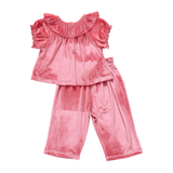 Pink velvet top and pants set on a white background