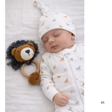 Baby sleeping with a lion rattle and patterned outfit on a white background