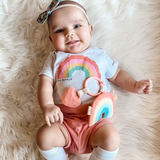 a baby with Rainbow Pal Plush and Teether