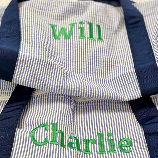 two monogrammed duffle bags