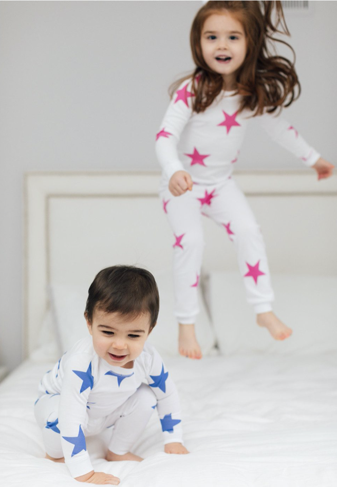 kids jumping on bed in star pajamas